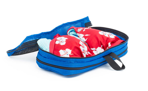 An open Island (blue) Aether Small Laundry Aeronaut 30 Packing Cube showing the mesh side and filled with a few bikinis.